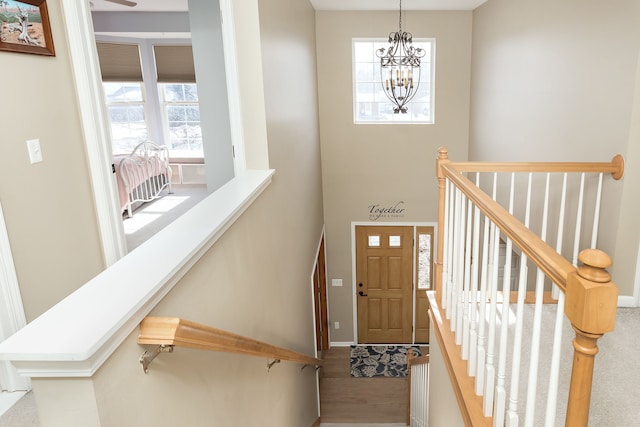 foyer entrance with hardwood / wood-style flooring, a healthy amount of sunlight, and a notable chandelier