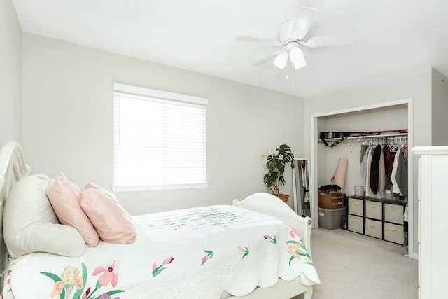 bedroom with ceiling fan, light carpet, and a closet