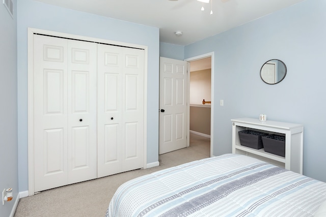 bedroom featuring light colored carpet and a closet