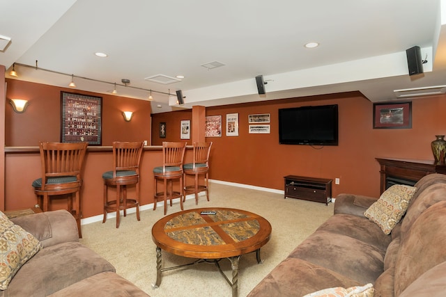 living room featuring track lighting, bar area, and light carpet