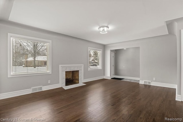 unfurnished living room with a premium fireplace and dark hardwood / wood-style flooring