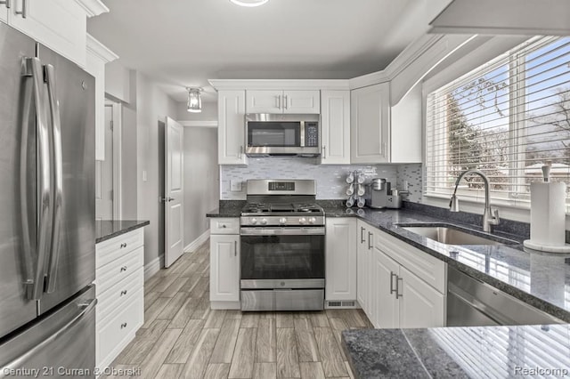 kitchen featuring backsplash, appliances with stainless steel finishes, sink, and white cabinets