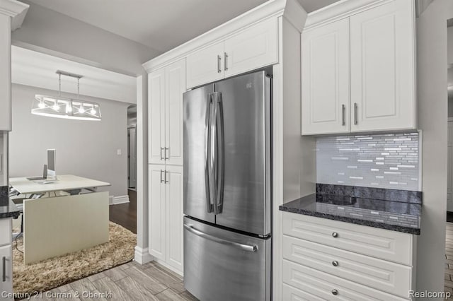 kitchen featuring white cabinets, tasteful backsplash, pendant lighting, and stainless steel fridge