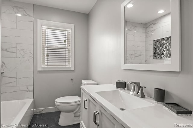 full bathroom with vanity, tiled shower / bath, and toilet