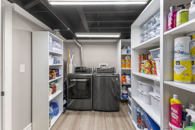 clothes washing area with hardwood / wood-style flooring and independent washer and dryer