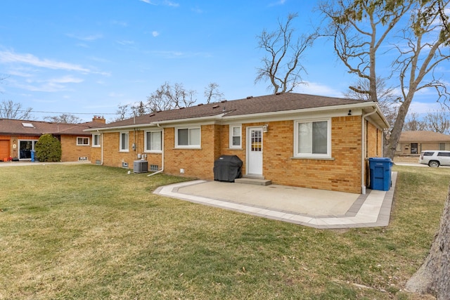 rear view of property with a yard, cooling unit, and a patio area