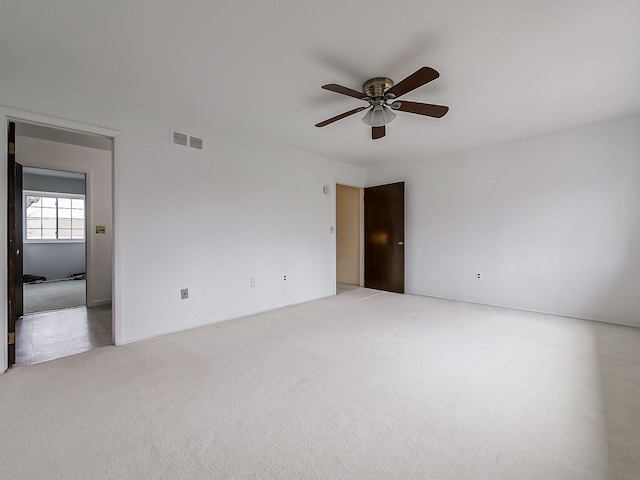 carpeted spare room with ceiling fan