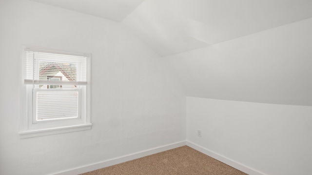 additional living space featuring carpet floors, vaulted ceiling, and baseboards