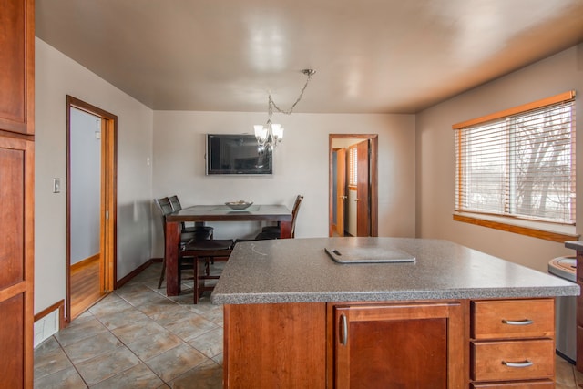 kitchen featuring hanging light fixtures, light tile patterned floors, a chandelier, and a kitchen island