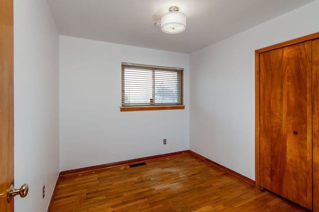 unfurnished bedroom with hardwood / wood-style flooring and a closet