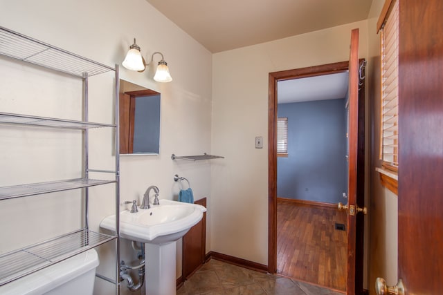 bathroom featuring wood-type flooring, toilet, and sink