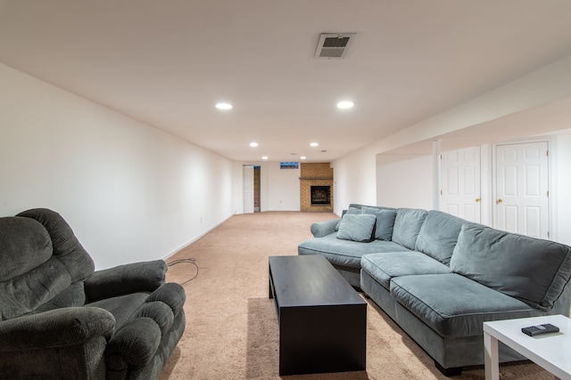 living room featuring a fireplace and light colored carpet