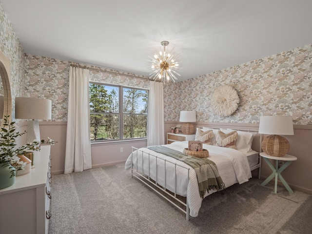 carpeted bedroom with a wainscoted wall, baseboards, wallpapered walls, and a notable chandelier