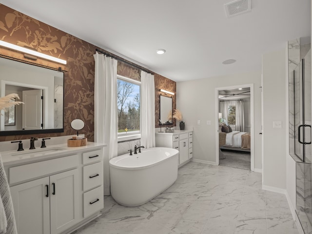 full bath featuring wallpapered walls, a healthy amount of sunlight, marble finish floor, and a sink