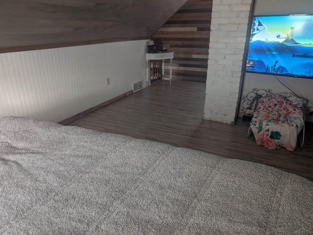 bonus room featuring wood-type flooring, vaulted ceiling, and wood walls