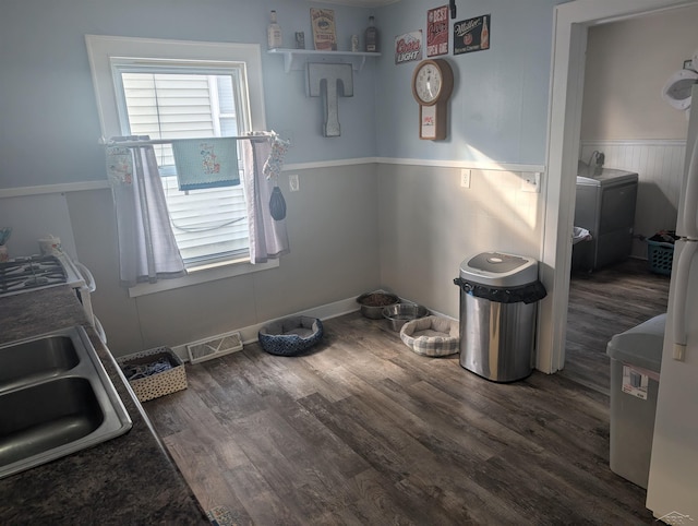 laundry area featuring dark hardwood / wood-style flooring, sink, and washer / dryer