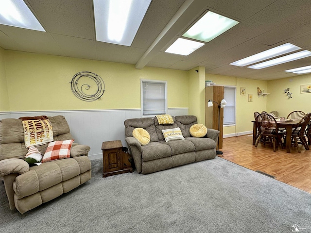 living room with a drop ceiling and hardwood / wood-style floors