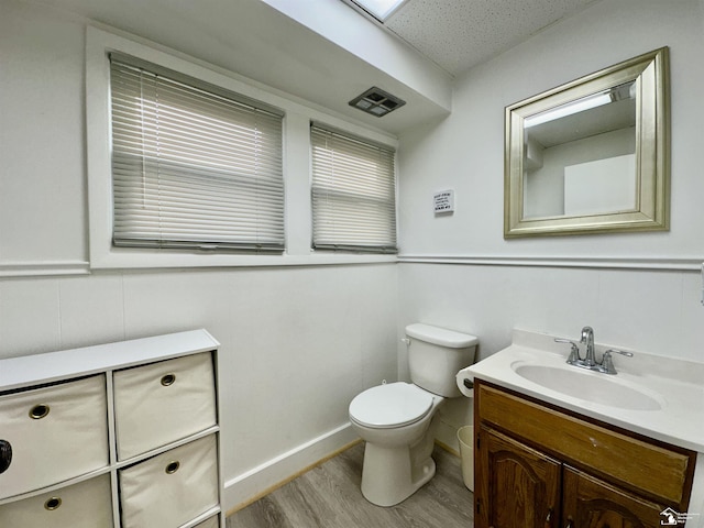 bathroom featuring vanity, wood-type flooring, and toilet