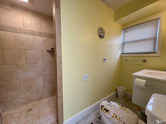 bathroom featuring toilet, sink, and tiled shower