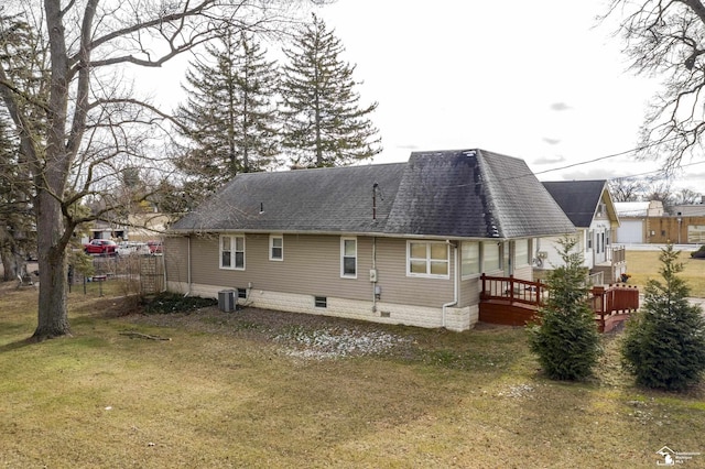 back of property with central AC, a wooden deck, and a lawn