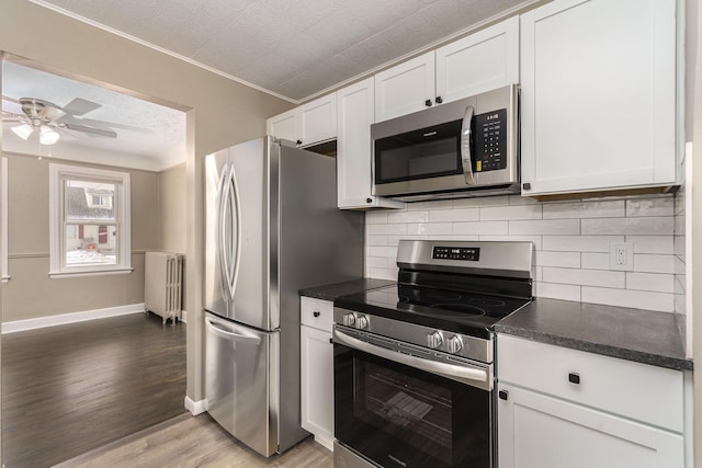 kitchen featuring white cabinetry, radiator, and stainless steel appliances