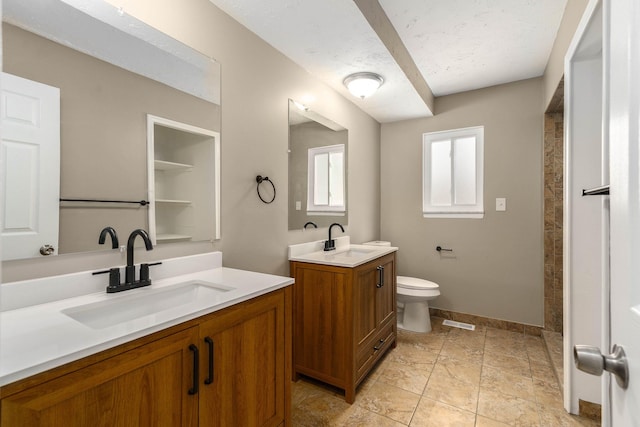 bathroom with vanity, toilet, and a textured ceiling