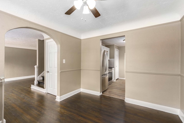 spare room with ceiling fan, dark wood-type flooring, and a textured ceiling