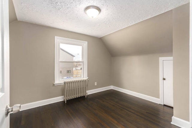 bonus room with lofted ceiling, dark wood-type flooring, radiator heating unit, and a textured ceiling