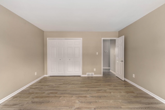 unfurnished bedroom with hardwood / wood-style flooring and a closet