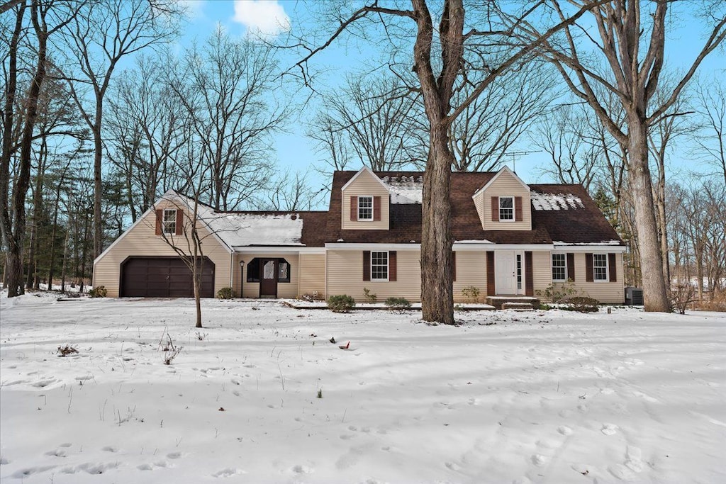 new england style home with a garage and cooling unit