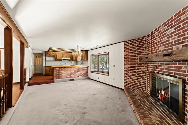 unfurnished living room featuring brick wall, carpet floors, and a fireplace