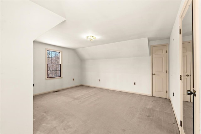 additional living space with vaulted ceiling and light colored carpet