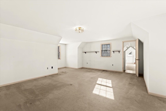 additional living space featuring lofted ceiling and light carpet