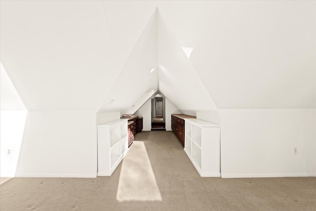 bonus room featuring vaulted ceiling and light colored carpet