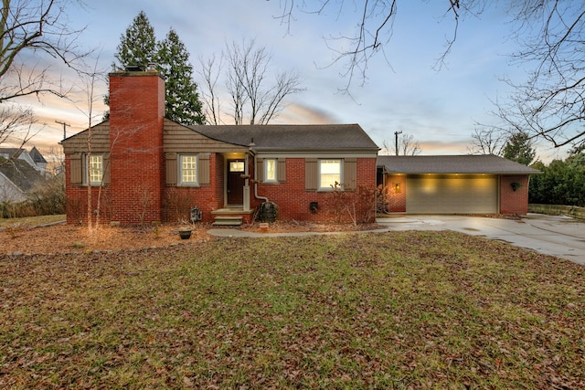 view of front of home with a garage and a lawn