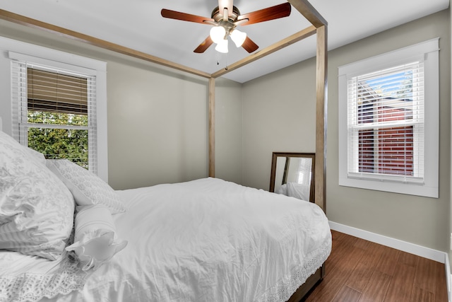 bedroom with ceiling fan, dark hardwood / wood-style floors, and multiple windows