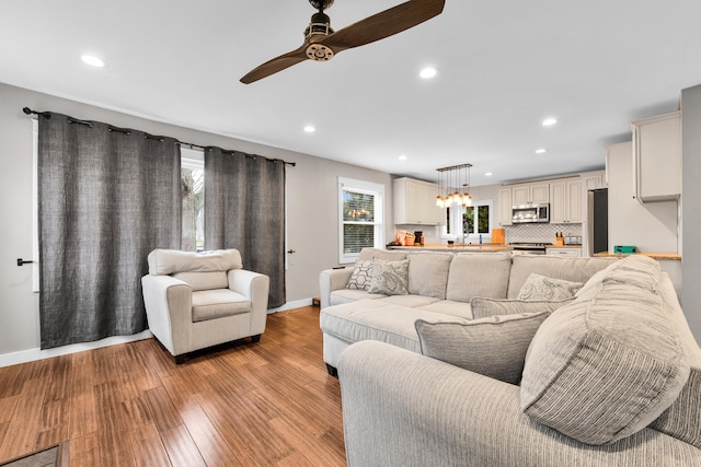 living room with light hardwood / wood-style floors and ceiling fan