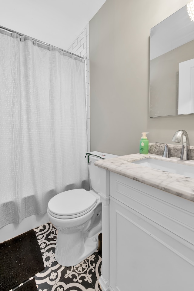 full bathroom with vanity, tile patterned floors, toilet, and shower / tub combo with curtain