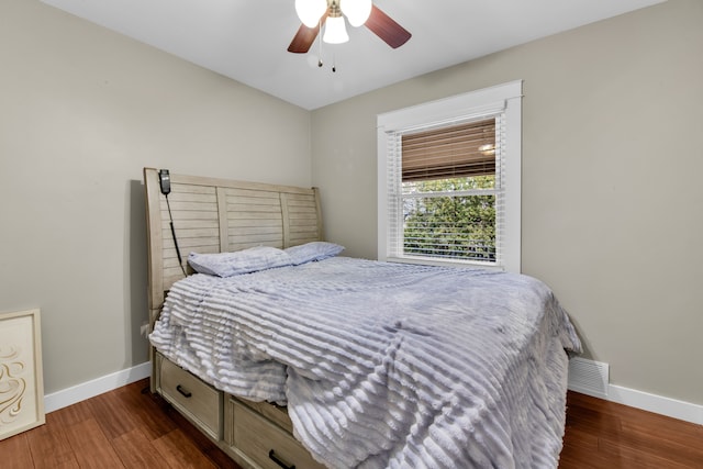 bedroom with dark hardwood / wood-style flooring and ceiling fan