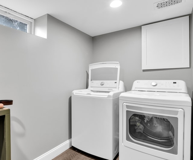 clothes washing area featuring dark wood-type flooring and washing machine and clothes dryer