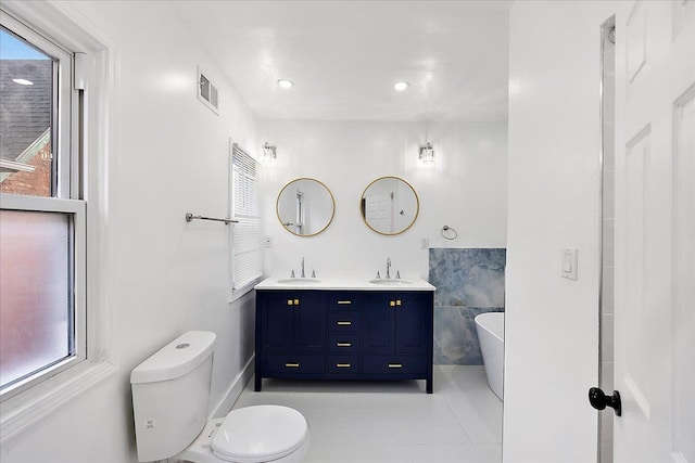 bathroom with a bathing tub, vanity, and toilet