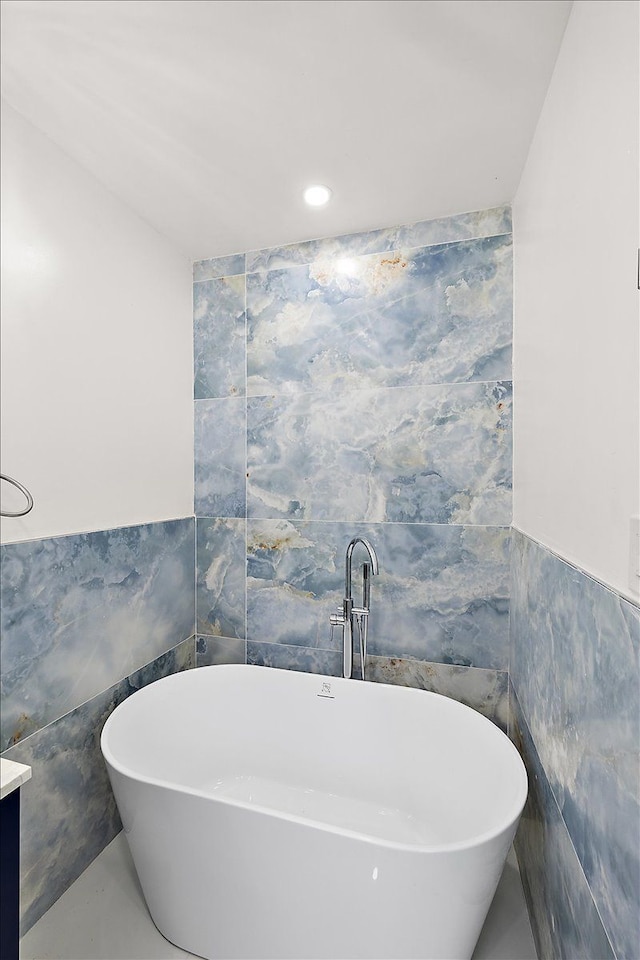 bathroom featuring vanity, tile walls, and a bathtub