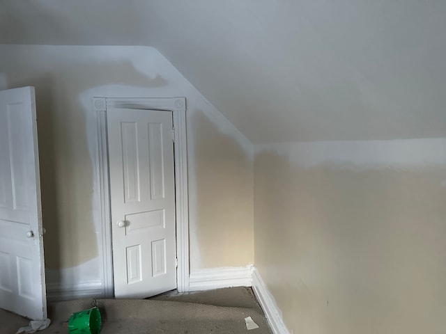 bonus room featuring dark colored carpet and lofted ceiling