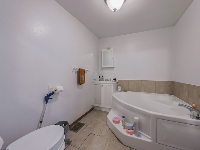 bathroom featuring tile patterned flooring, a tub, and toilet