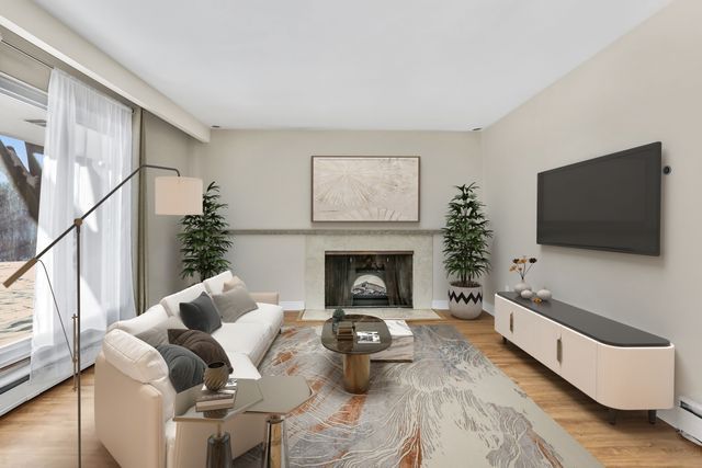 living room featuring a high end fireplace and light wood-type flooring