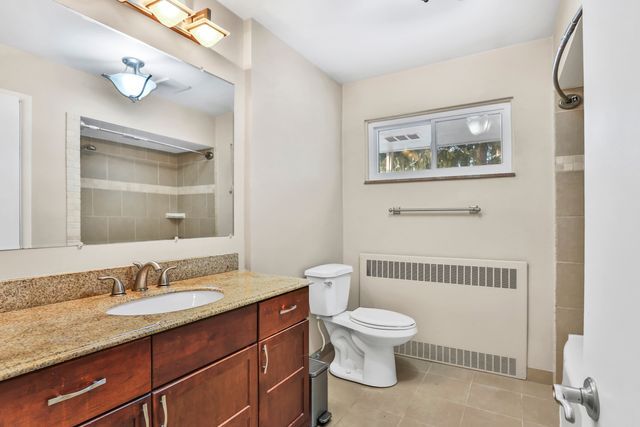 bathroom with vanity, radiator, tile patterned floors, and toilet