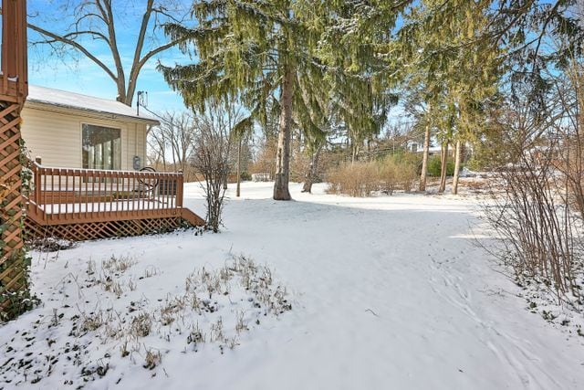 yard layered in snow with a wooden deck