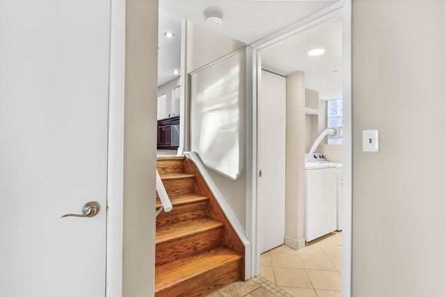 stairway with washer / clothes dryer and tile patterned floors