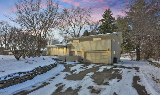 view of snow covered exterior featuring a garage