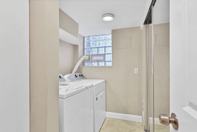 laundry room with washer and clothes dryer and light tile patterned floors